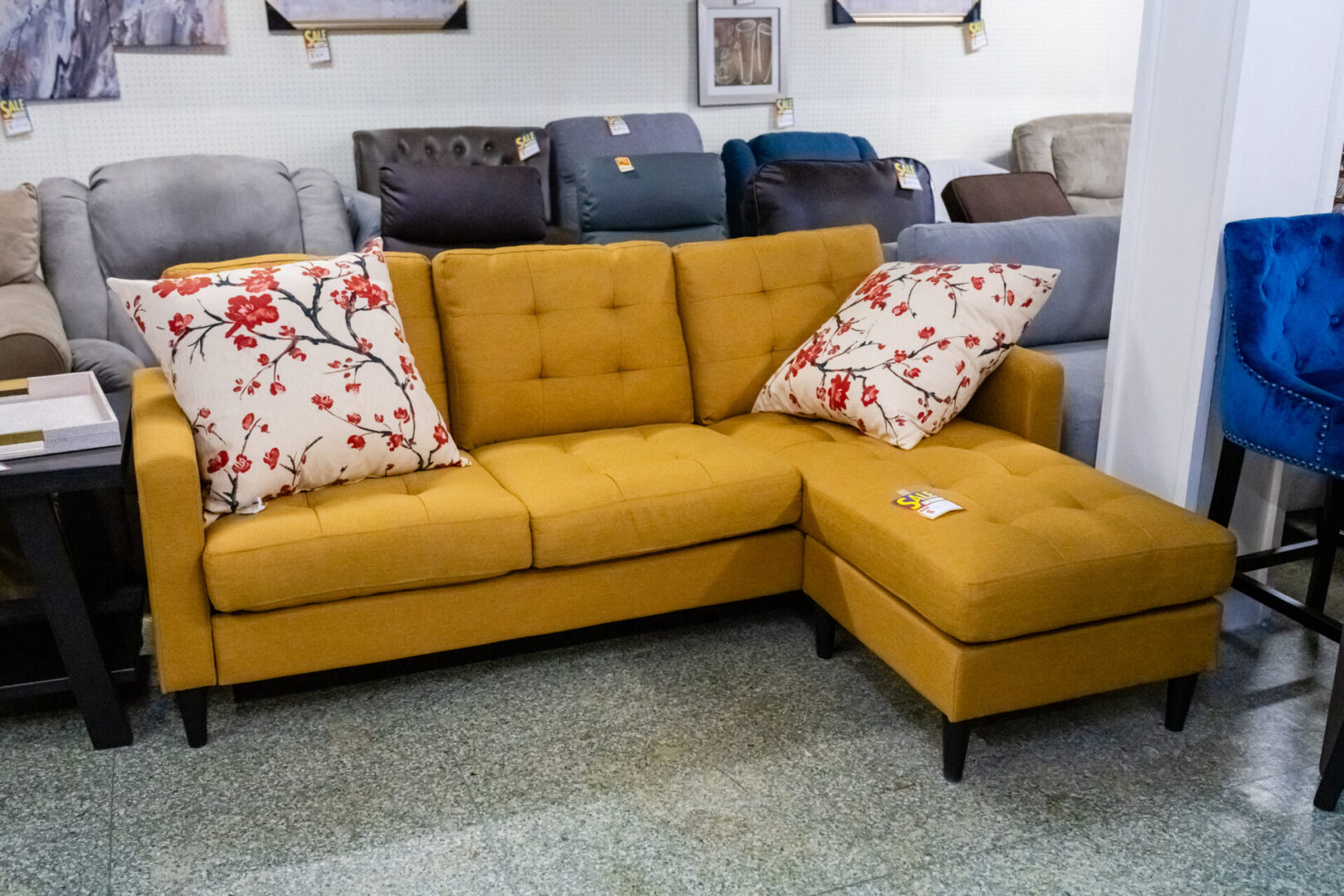 A yellow couch with two pillows on it