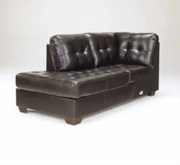 A brown leather couch with pillows on it.